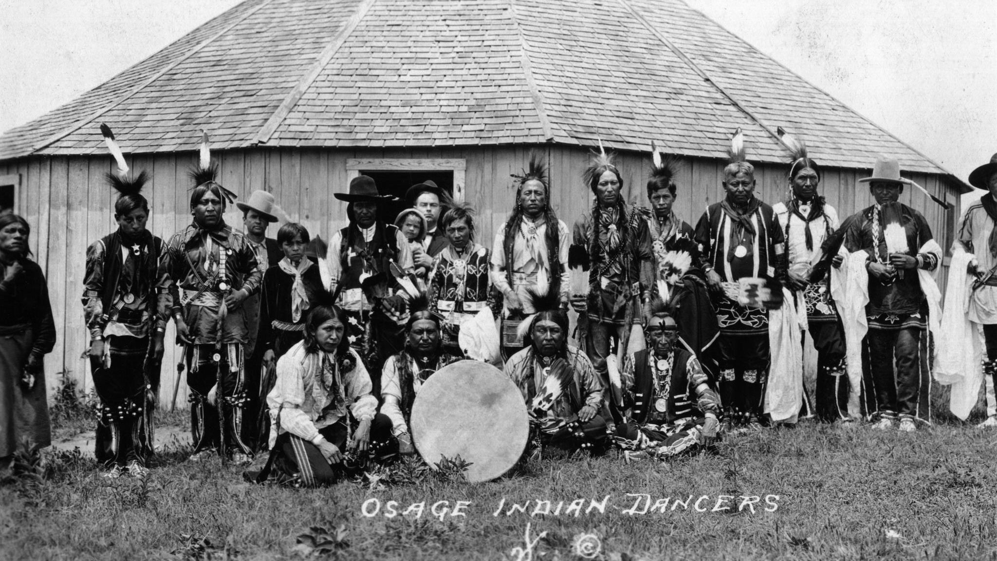 Fotografie einer Gruppe von Tänzern der Osage. Viele von ihnen tragen Kopfschmuck Das Öl bringt den Osage – hier eine Tanzgruppe – nicht nur nie gekannten Wohlstand, sondern auch neue Sorgen. Bald häufen sich mysteriöse Todesfälle