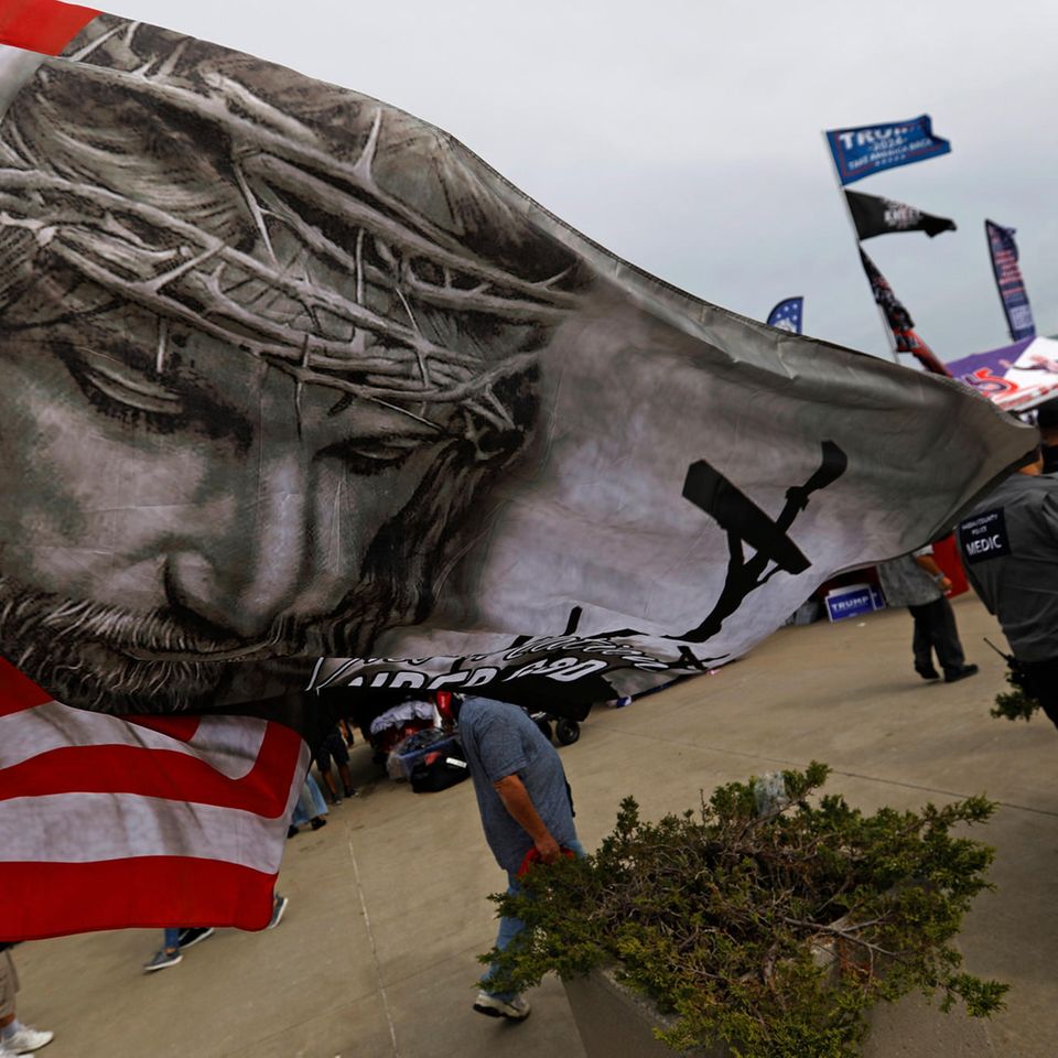 Eine amerikanische Flagge mit dem gekreuzigten Christus weht bei einem Auftritt Donald Trumps im September 2024. Die Mehrheit weißer Evangelikaler hat bei den vergangen zwei Wahlen für ihn gestimmt