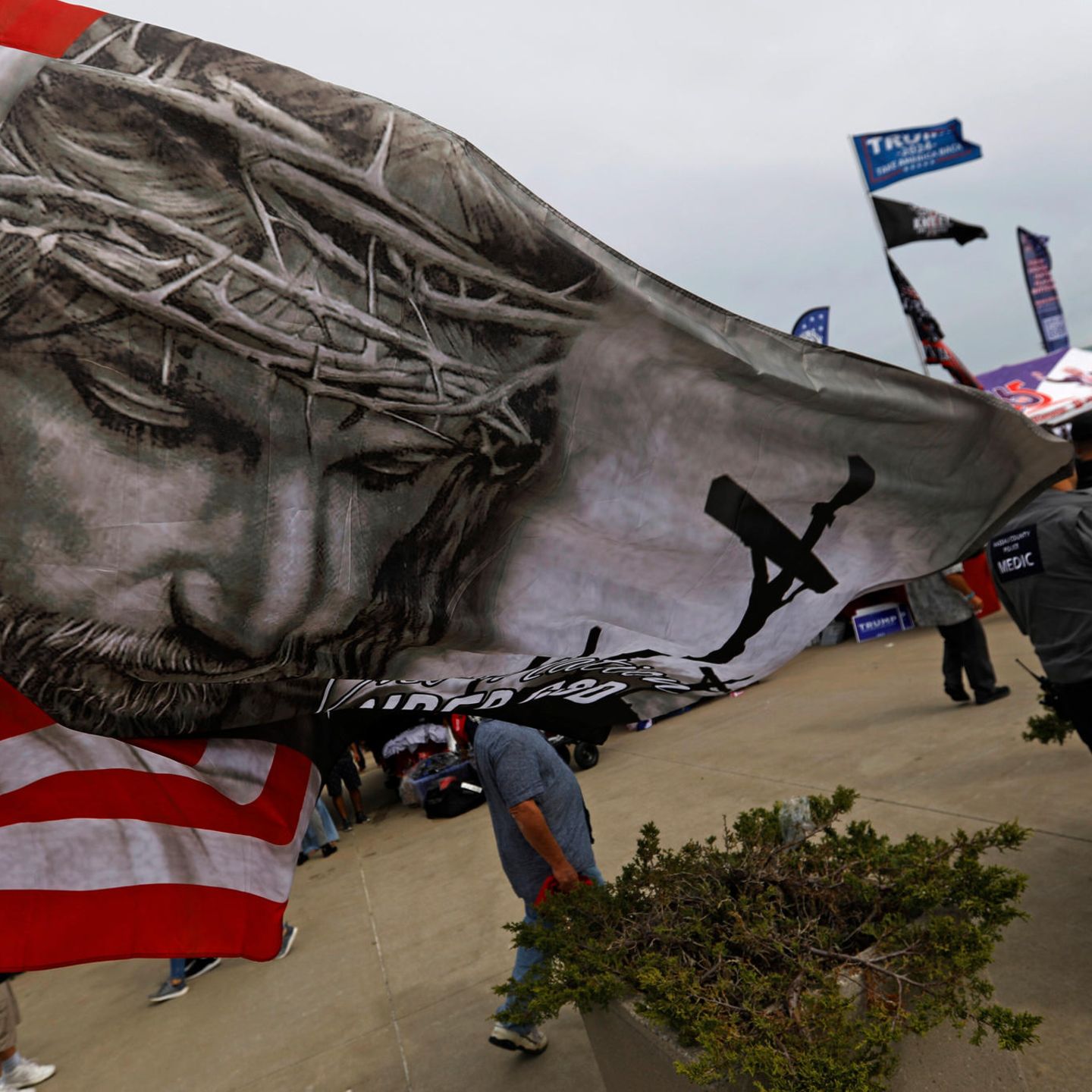 Eine amerikanische Flagge mit dem gekreuzigten Christus weht bei einem Auftritt Donald Trumps im September 2024. Die Mehrheit weißer Evangelikaler hat bei den vergangen zwei Wahlen für ihn gestimmt