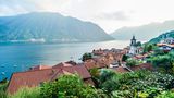Dorf am See mit Bergen im Hintergrund