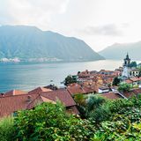 Dorf am See mit Bergen im Hintergrund