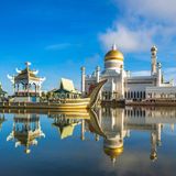 Omar Ali Saifuddien Moschee in Bandar Seri Begawan, Brunei. Im Vordergrund sind ein kleiner Teich und ein Boot zu sehen.