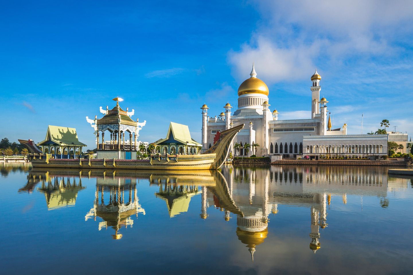 Omar Ali Saifuddien Moschee in Bandar Seri Begawan, Brunei. Im Vordergrund sind ein kleiner Teich und ein Boot zu sehen.
