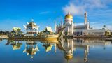 Omar Ali Saifuddien Moschee in Bandar Seri Begawan, Brunei. Im Vordergrund sind ein kleiner Teich und ein Boot zu sehen.