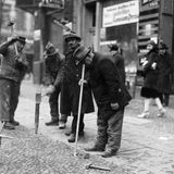 Mann führt Rohr in Fußboden ein