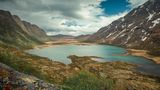 Turquoise lake surrounded by mountain landscape at Knutshoe summit in Jotunheimen National Park in Norway
