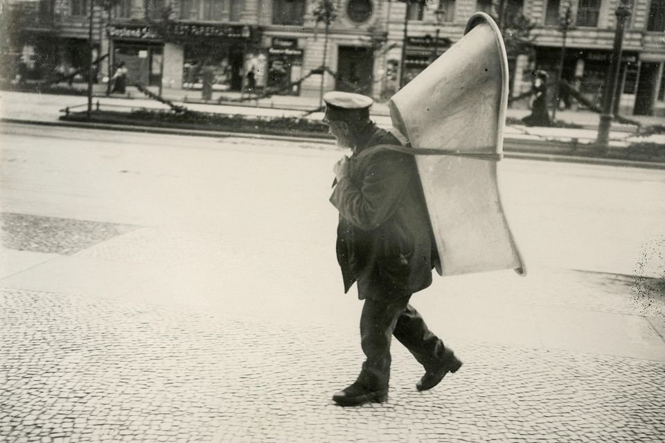 Mann trägt Badewanne auf Rücken