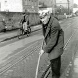 Mann säubert mit Schaufel Gleise