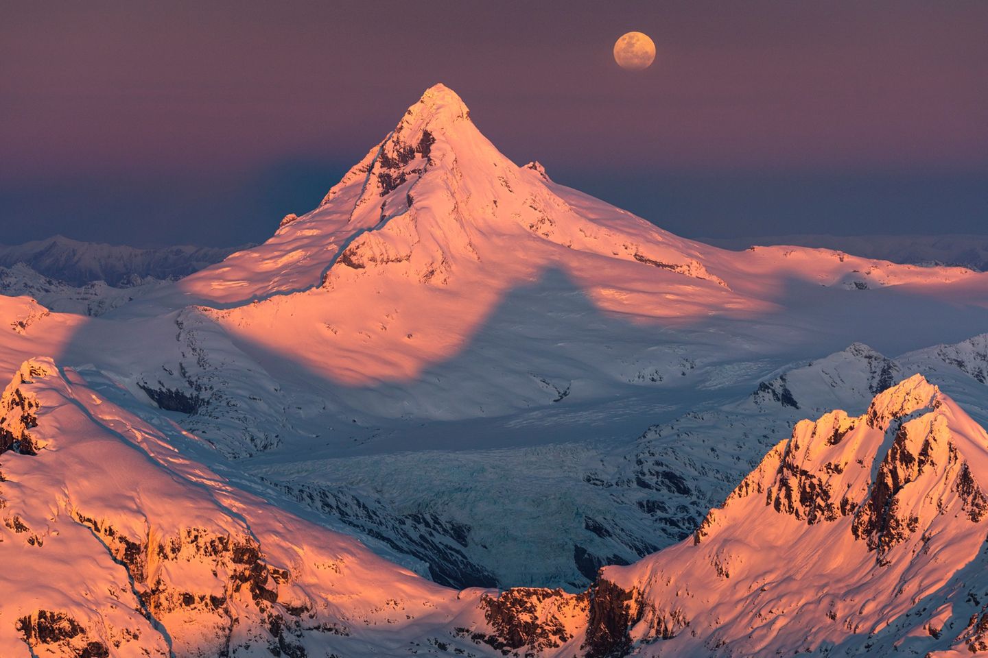 Vollmond über schneebedeckten Bergen