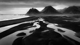 Schwarz-weiß Fotografie zeigt Strand vor dem Berg Vestrahorn in Island