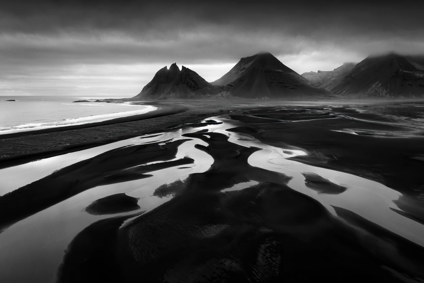 Schwarz-weiß Fotografie zeigt Strand vor dem Berg Vestrahorn in Island