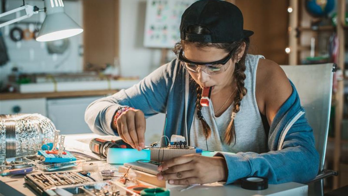 Eine Frau repariert ein Elektro-Gerät