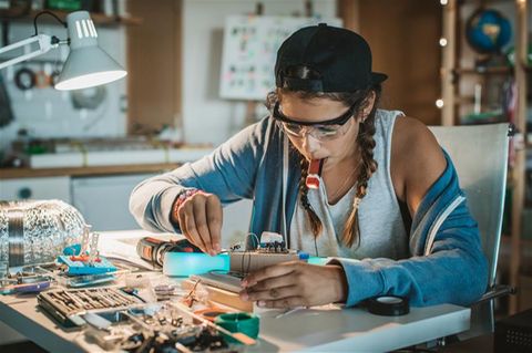Eine Frau repariert ein Elektro-Gerät