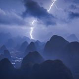Power of Nature  Eigentlich hatte Kelvin Yuen ein ganz anderes Motiv im Sinn: Er wollte den friedlichen Sonnenaufgang über den Bergen der chinesischen Karstlandschaft in der Nähe von Guilin einfangen. Als er um drei Uhr morgens aufstand und den Berg erklomm, braute sich allerdings wie aus dem Nichts ein enormes Gewitter zusammen. Er ließ seine Drohne steigen und konnte damit die dramatische Kraft der Natur in einem ganz besonderen Panorama festhalten. Diese spektakuläre Aufnahme sicherte ihm sowohl den Sieg als "Photograph des Jahres" als auch den ersten Platz in der Kategorie "Nature/Landscape".
