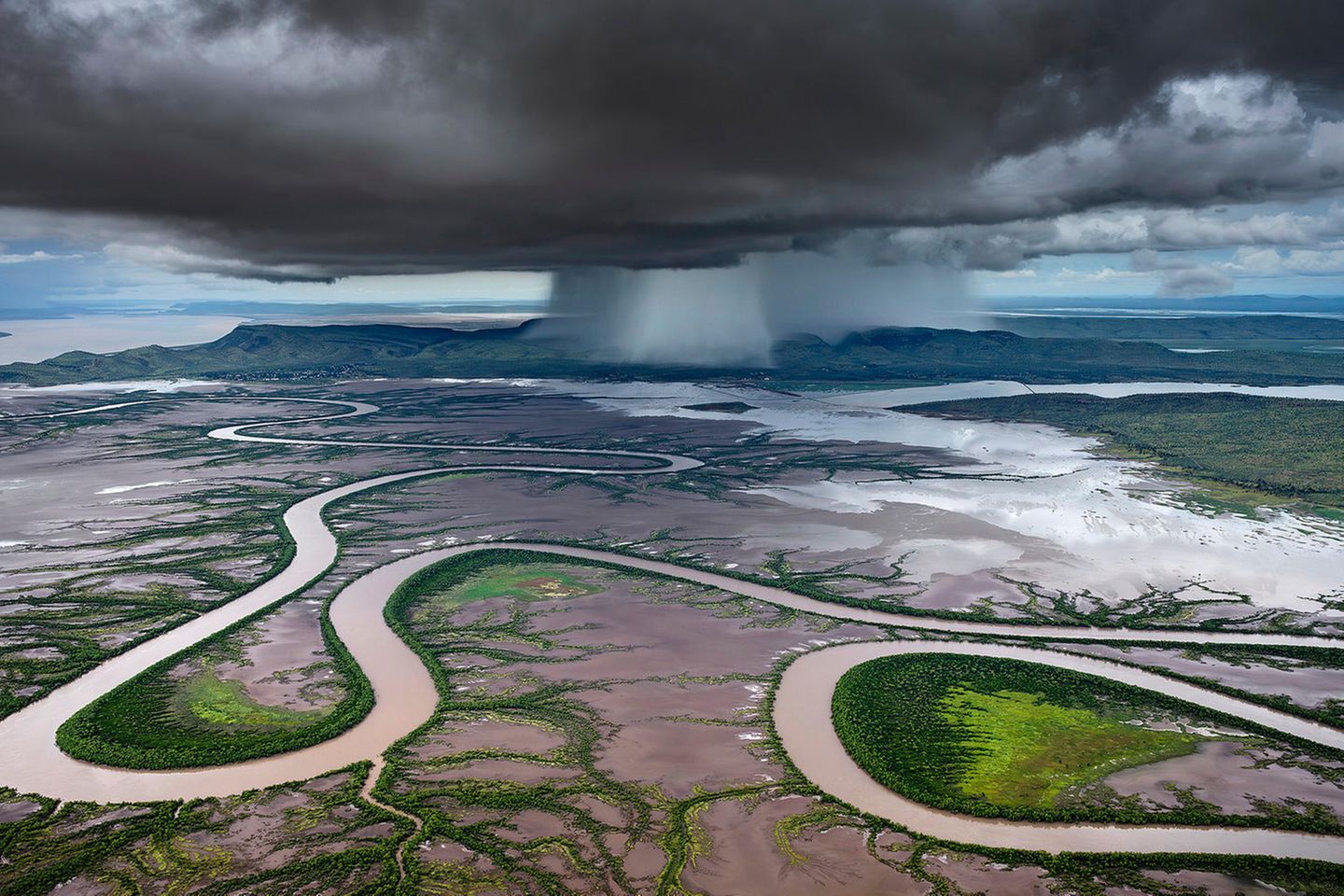 Storm Dump  Wie eine Schlange windet sich der Kings-River durch die Ebenen von Kimberley, einem Bundesstaat in Westaustralien. Im Hintergrund entladen sich bedrohliche Regenwolken. Während der Monsunzeit von Oktober bis April erwacht die ansonsten trockene Landschaft zum Leben und es kommt zu sintflutartigen Regenfällen. Der Fotograf Tom Putt hat diesen besonderen Moment während eines Helikopterflugs festgehalten und wurde dafür mit dem "Curator's Award" des diesjährigen Epson International Pano Awards ausgezeichnet. 