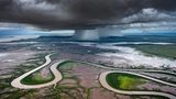 Storm Dump  Wie eine Schlange windet sich der Kings-River durch die Ebenen von Kimberley, einem Bundesstaat in Westaustralien. Im Hintergrund entladen sich bedrohliche Regenwolken. Während der Monsunzeit von Oktober bis April erwacht die ansonsten trockene Landschaft zum Leben und es kommt zu sintflutartigen Regenfällen. Der Fotograf Tom Putt hat diesen besonderen Moment während eines Helikopterflugs festgehalten und wurde dafür mit dem "Curator's Award" des diesjährigen Epson International Pano Awards ausgezeichnet. 