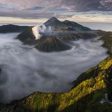 The Volcanoes Theatre  Bei Sonnenaufgang wabern Nebelschwaden träge im Krater des Vulkans Bromo auf der indonesischen Insel Java. Als einer der aktivsten Vulkane auf Java ist der 2329 Meter hohe Berg ein beliebtes Touristenziel im Nationalpark Bromo-Tengger-Semeru. Die Fotografin Fikri Muharom gewann mit ihrer 180°-Drohnenaufnahme der Vulkankette den ersten Preis in der Kategorie "Southeast Asia Open Photographer of the Year". 