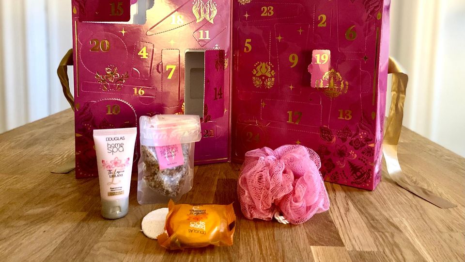 pinkfarbener Adventskalender mit offenen Türchen und Pflegeprodukten