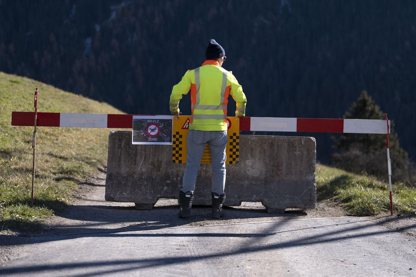 Mann in Warnweste steht vor Straßenabsperrung