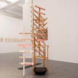 Ein Kunstwerk aus einem Holzgestell und einem schwarzen Bottich