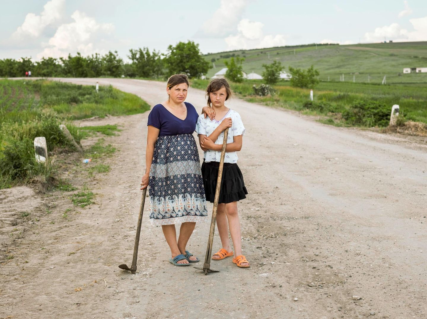 Mutter und Tochter auf dem Weg nach Hause von der Feldarbeit. Sie arbeiten als Tagelöhnerinnen