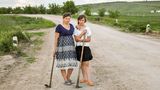 Mutter und Tochter auf dem Weg nach Hause von der Feldarbeit. Sie arbeiten als Tagelöhnerinnen