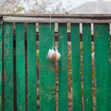 Tasse am Gartenzaun, um bei der Gartenarbeit Wasser aus dem Brunnen trinken zu können