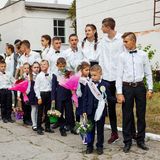 Eine Gruppe Schüler mit Erstklässlern, die Blumensträuße in den Händen halten
