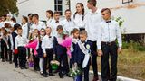 Eine Gruppe Schüler mit Erstklässlern, die Blumensträuße in den Händen halten