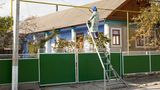 Hier streicht eine Seniorin die oberirdische Gasleitung an der Hauptstraße