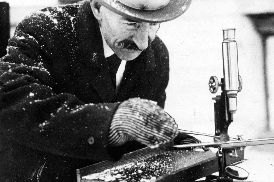 Wilson Bentley mit Hut, Mantel und Handschuhen draußen beim Schneeflocken-Fotografieren 0.75