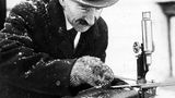 Wilson Bentley mit Hut, Mantel und Handschuhen draußen beim Schneeflocken-Fotografieren