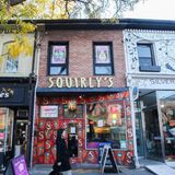 Alte Häuser mit Shops, daneben ein Baum