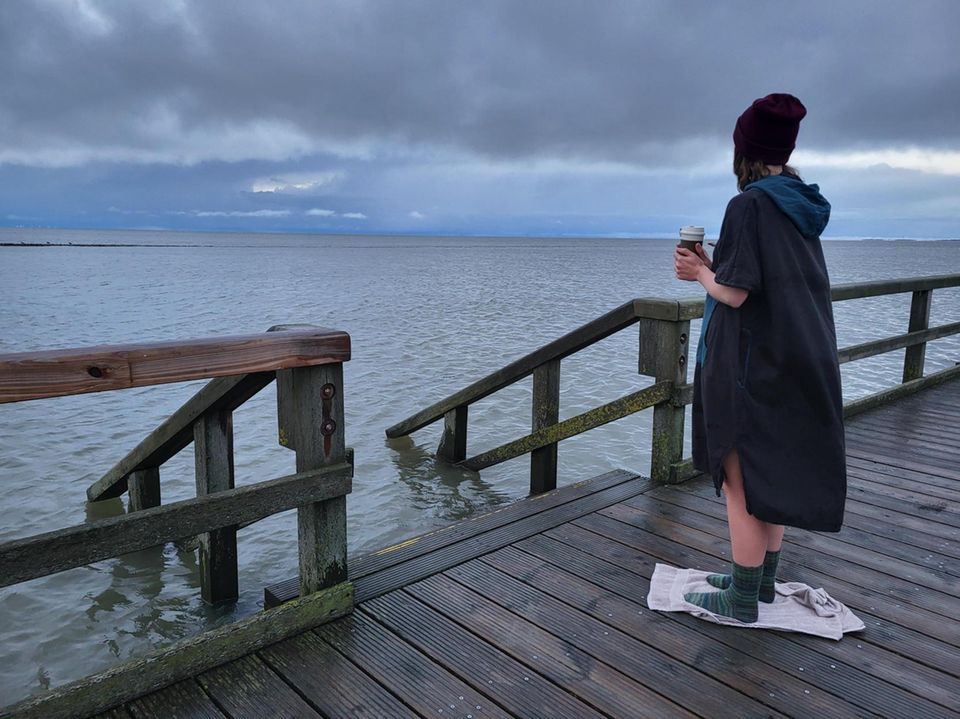 Nach dem Winterbaden mit Surfponcho, Mütze, Wollsocken und Thermobecher