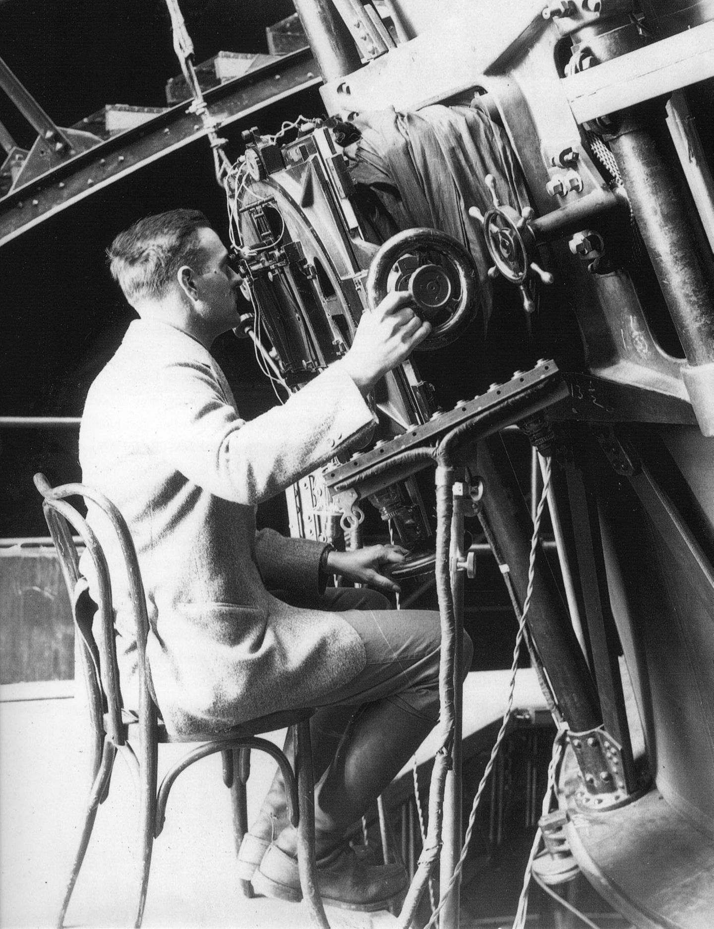 Edwin Hubble sitzt auf einem Stuhl und benutzt das 100 inch Hooker Teleskop