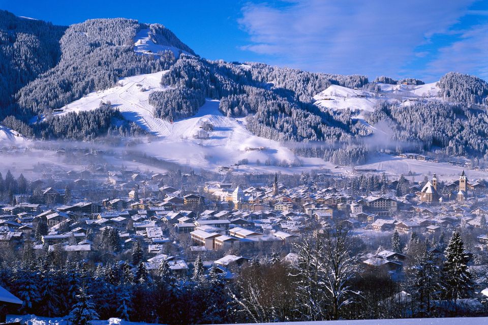 Verschneiter Hang mit Abfahrt, unten die Stadt 1.28