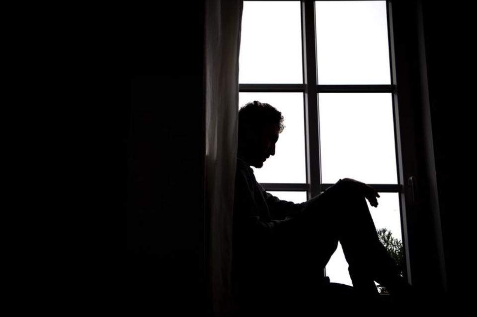 Mann sitzt am Fenster