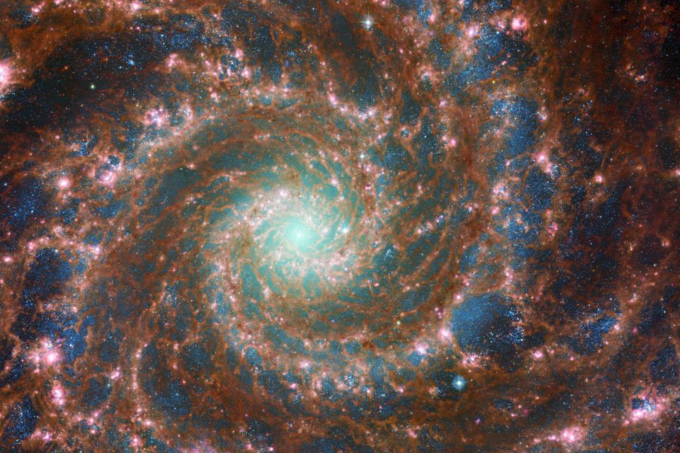 An der Spiralgalaxie Messier 74 zeigt sich eindrucksvoll, wie ungleichmäßig interstellare Materie in Galaxien verteilt ist. Manche Gebiete sind fast frei von ihr (dunkle Blasen mit bläulichen Sternen), dazwischen knubbeln sich Gas und Staub (rötlich leuchtend): Dort entstehen neue Sterne (pink) 1.6101