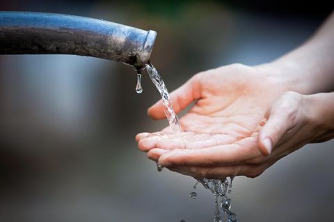 Hände unter einem laufenden Wasserhahn