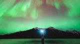 Im kanadischen Banff-Nationalpark fotografierte Herry Himanshu eine Freundin mit Stirnlampe unter einem in Rot-, Rosa- und Violetttönen flirrenden Nachthimmel.