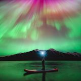 Im kanadischen Banff-Nationalpark fotografierte Herry Himanshu eine Freundin mit Stirnlampe unter einem in Rot-, Rosa- und Violetttönen flirrenden Nachthimmel.