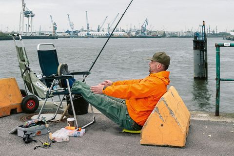 Angler macht Yoga am Wasser