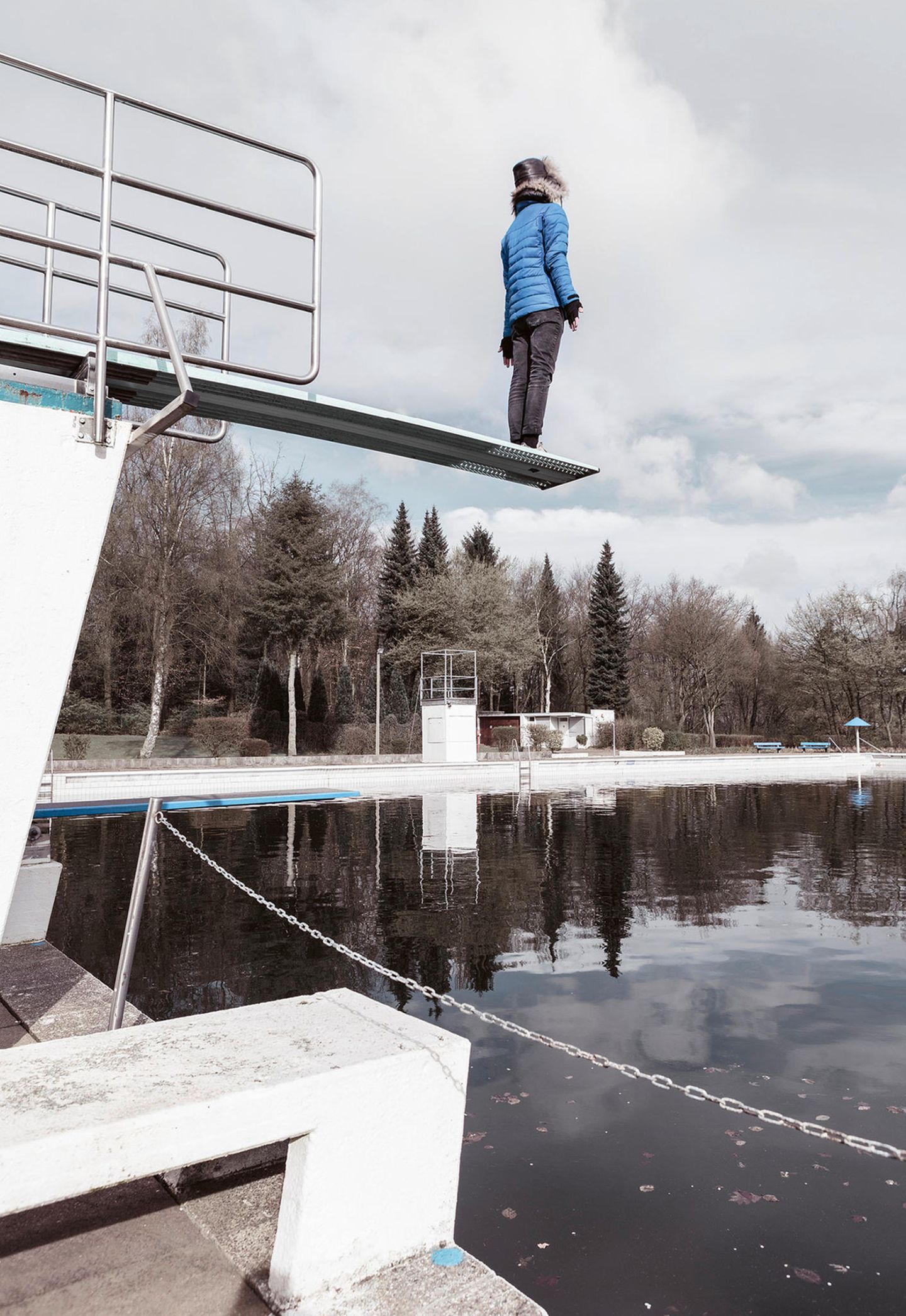 Der Berg (tadasana) Person macht Yoga auf einem Sprungbrett im Schwimmbad