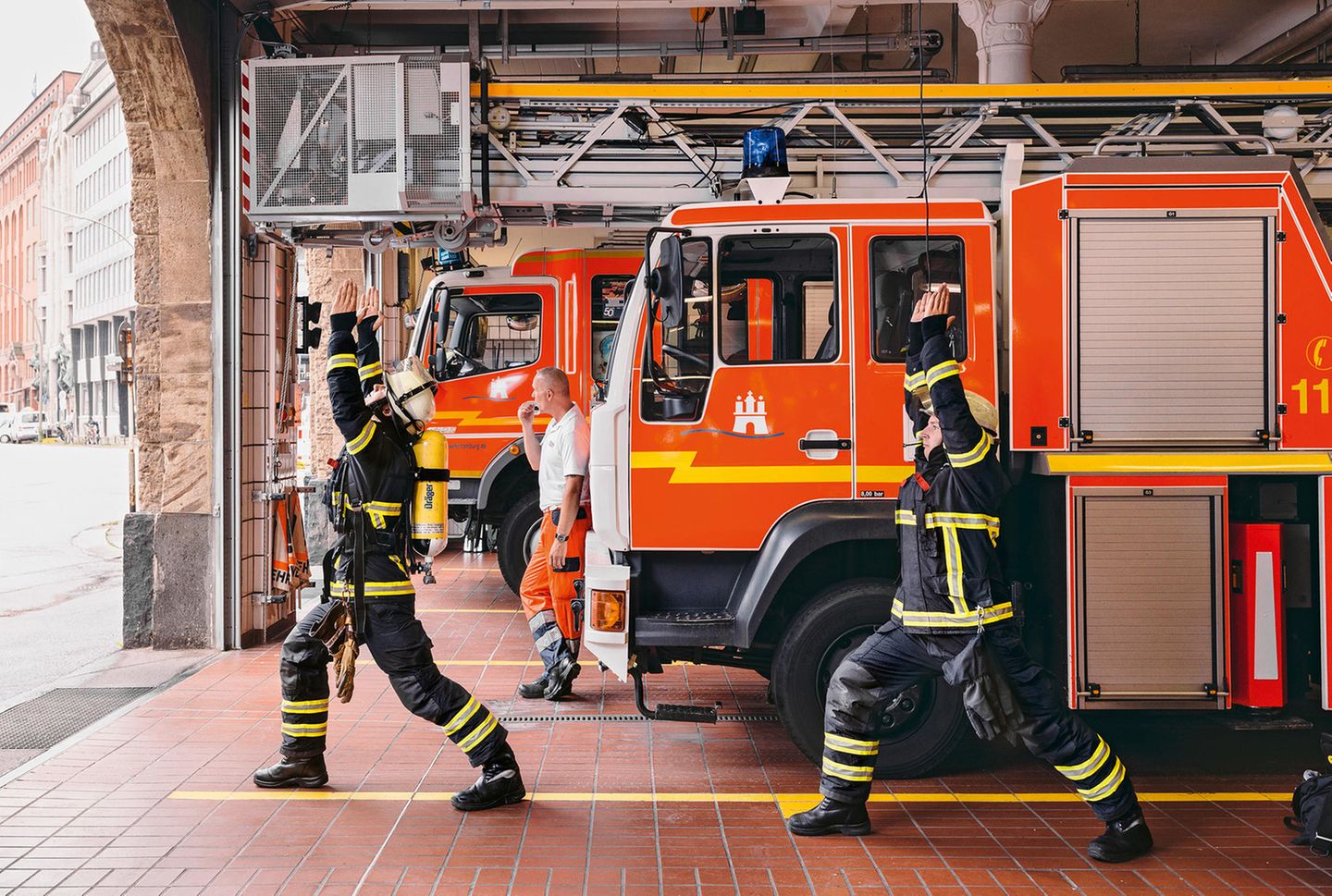 Der erste Held (virabhadrasana 1) Feuerwehrmänner machen Yoga in der Feuerwache