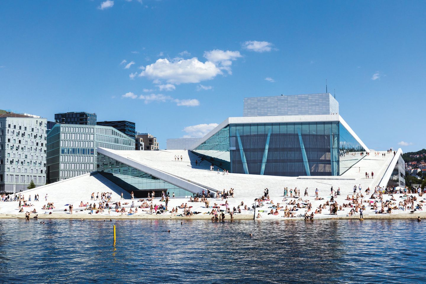 Viele Gäste auf den Treppen des Opernhaus. Manche von ihnen Baden im Wasser