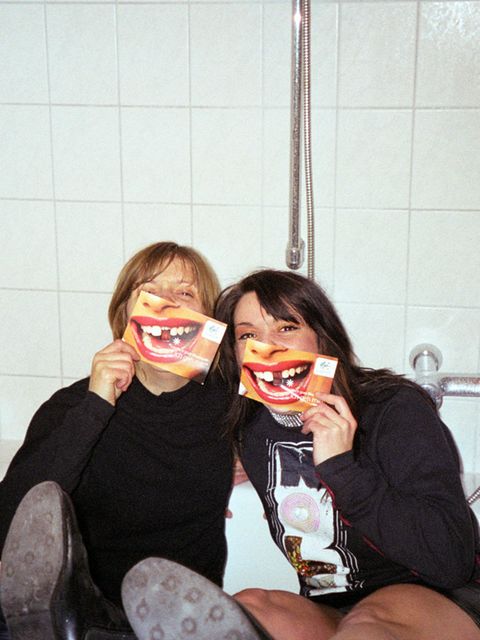 Ausgelassene Freundinnen posieren in Badewann für ein quatschiges Foto.