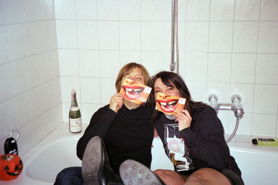Ausgelassene Freundinnen posieren in Badewann für ein quatschiges Foto. 1.5329