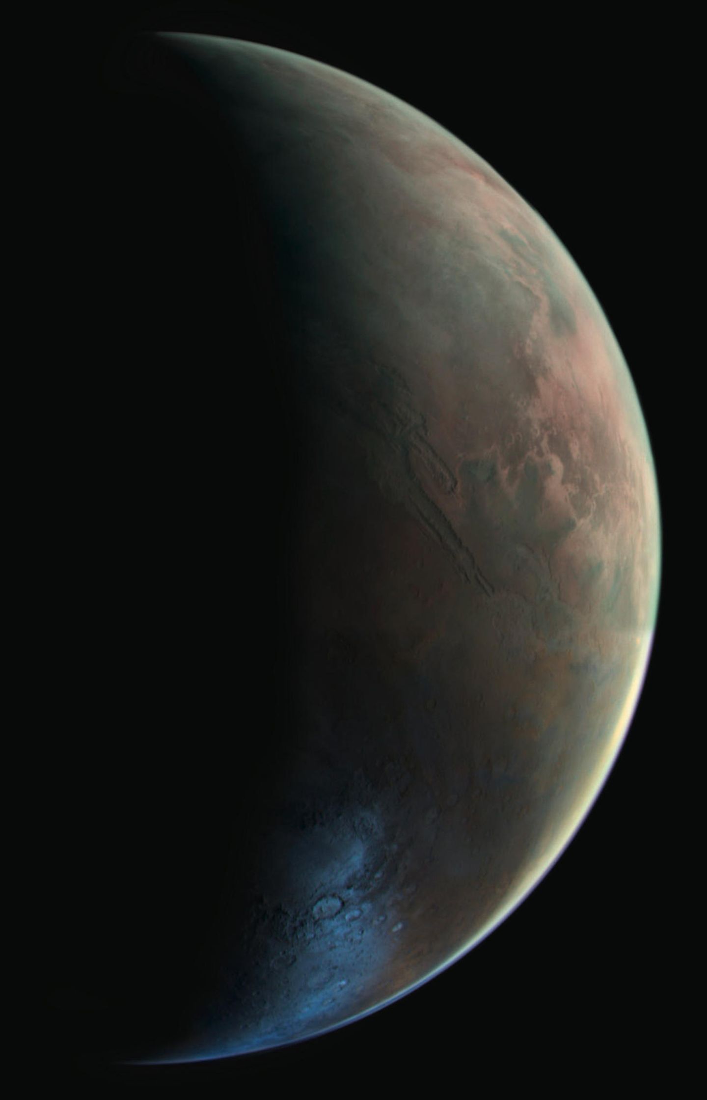 1976 nimmt die Raumonde Viking 2 diese sichelförmige Ansicht des Mars auf. Am hellen Rand der Scheibe wird das Sonnenlicht durch Staub- und Eiskristalle gefiltert und reflektiert. Im winterlichen Süden glänzt Morgenfrost im Hellas-Becken.