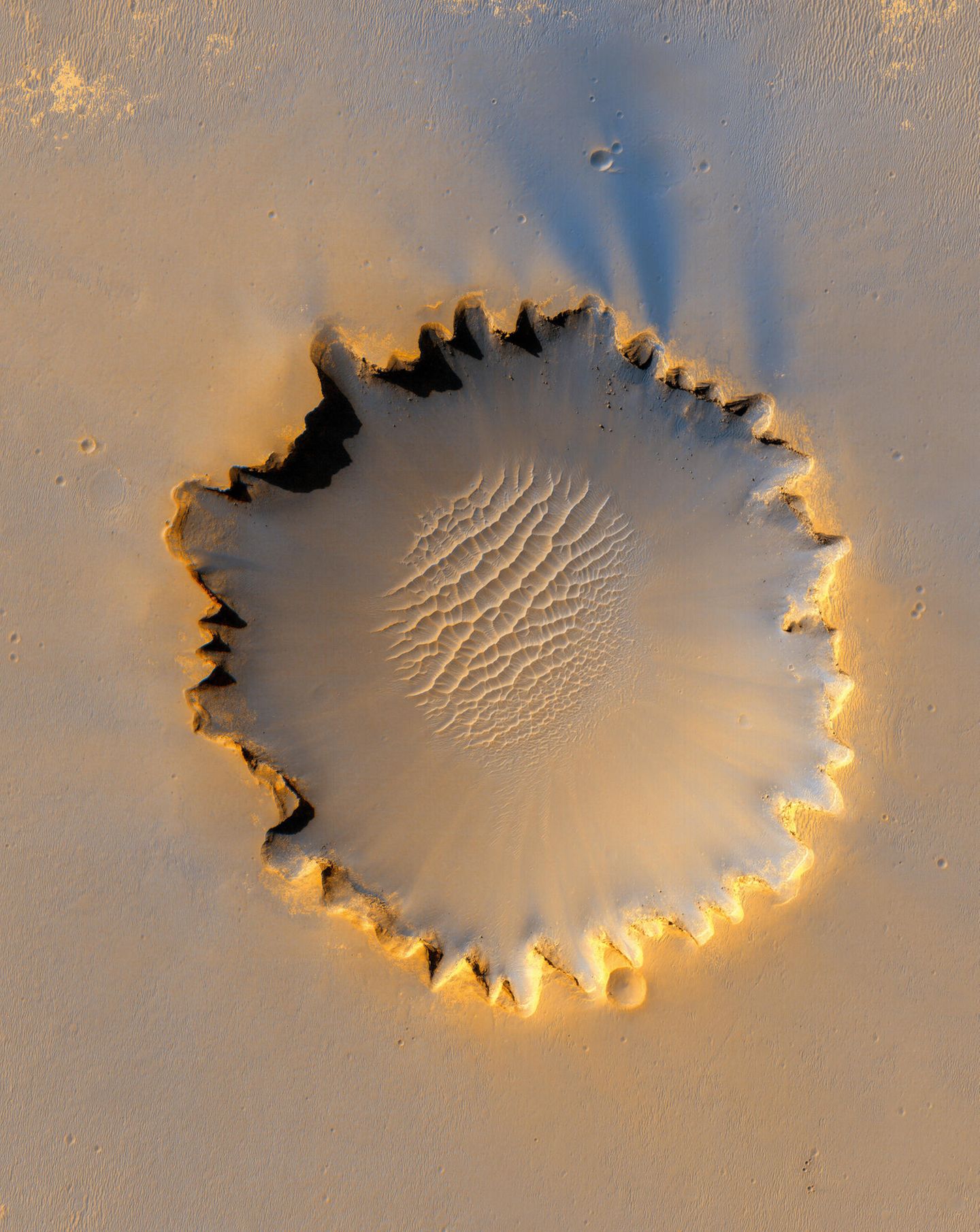 Am 951. Tag seiner Mission erreichte der Rover Opportunity den 800 Meter durchmessenden Victoria-Krater. Just in dem Moment schoss der Mars Reconnaissance Orbiter diese Aufnahme aus seiner Mars-Umlaufbahn. Opportunity ist als winziger Fleck etwa auf der Position 10 Uhr zu sehen.