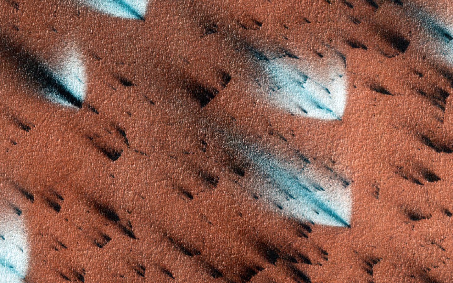 Inmitten der dunklen Sandfächer der auftauenden Polkappe lassen sich auch einige auffallend helle entdecken. Diese entstehen, wenn Kohlendioxidgas in kältere Luft ausströmt und als neuer Reif auf der staubigen Oberfläche kondensiert.